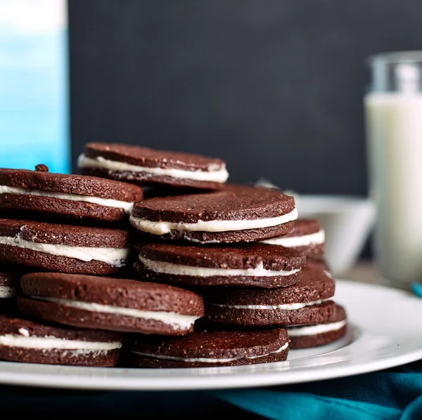 Çikolatalı sandviç çerezleri üzerinde ahşap arka plan doldurarak krema ile.