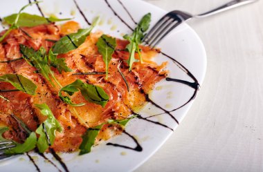 Beyaz tabak içinde somon carpacho