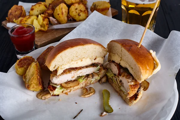 Hamburger di pollo tagliato in due metà con patate e birra — Foto Stock