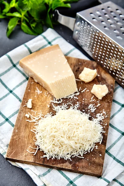 Кусок пармезана и тертого сыра — стоковое фото
