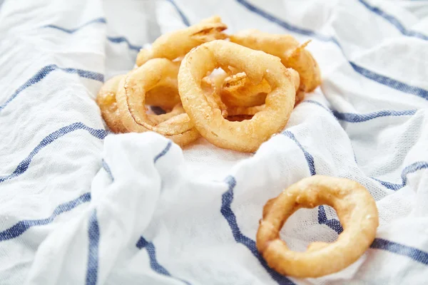 Onion rings on kitchen towel — Stock Photo, Image