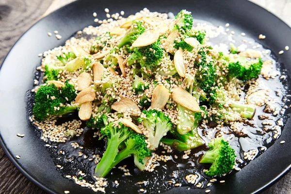 Steamed broccoli with garlic chips and sesame seeds