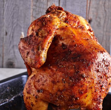 Ahşap arka plan üzerinde bütün kavrulmuş tavuk