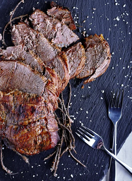 Roast beef on black stone board — Stock Photo, Image