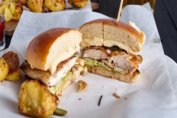 Hamburger di pollo tagliato in due metà con patate e birra — Foto Stock