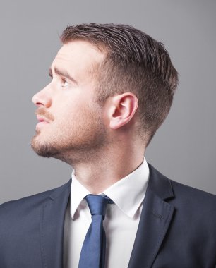 Gri arka plan üzerinde dalgın işadamı
