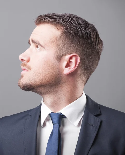 Pensive businessman on grey background Stock Image