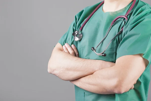 Doktor s stetoskop stojící s rukama přes — Stock fotografie