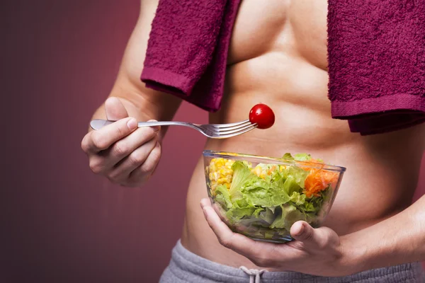 Hombre musculoso sosteniendo un tazón de ensalada —  Fotos de Stock