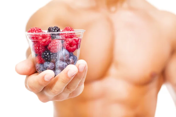Fit man holding a bowl of fresh fruits — Stock Photo, Image