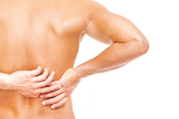 Muscular man holding his back in pain — Stock Photo, Image