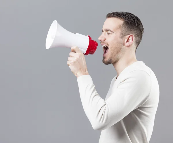 Jeune homme criant avec un mégaphone — Photo