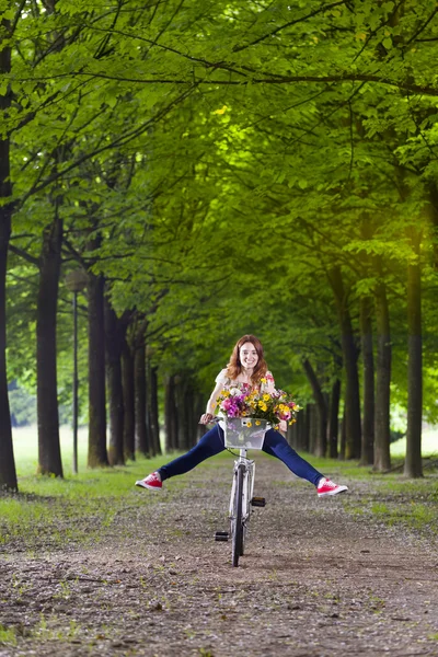 Kvinnan cykla i parken med benen — Stockfoto