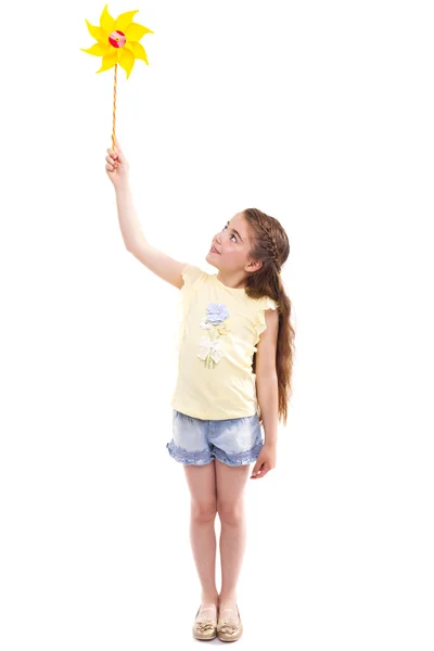 Glad flicka som leker med en leksak väderkvarn — Stockfoto