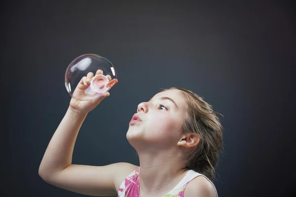 Linda menina soprando bolhas de sabão — Fotografia de Stock