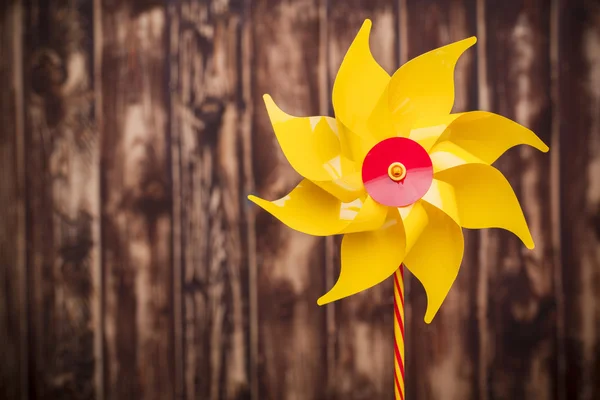 Pinwheel amarelo no fundo de madeira — Fotografia de Stock