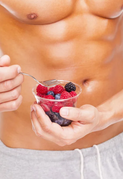 Fit man holding a bowl of fresh fruits — Stock Photo, Image