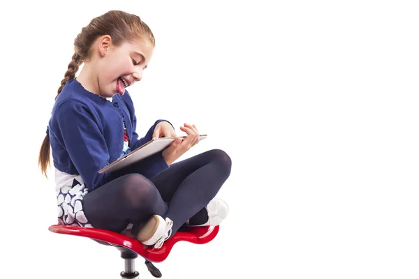 Menina usando um computador tablet na cadeira — Fotografia de Stock