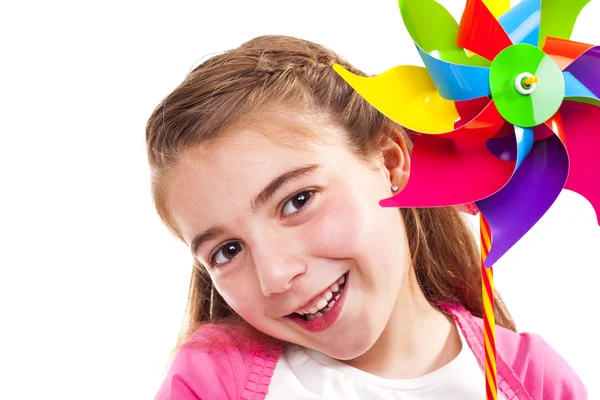 Menina feliz segurando um moinho de vento de brinquedo — Fotografia de Stock