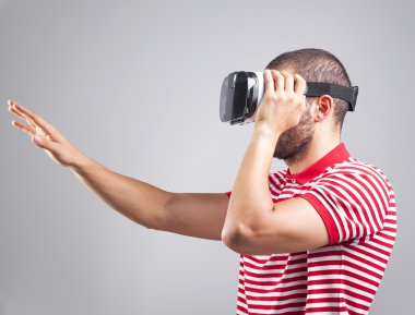 Adam sanal gerçeklik gözlüğü takıyor.