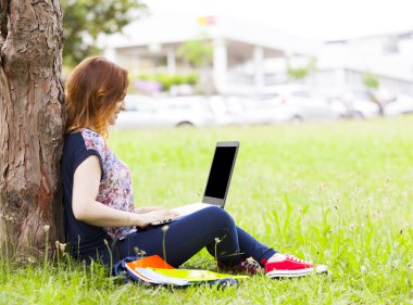 dizüstü bilgisayar kullanan çimenlerin üzerinde öğrenci kız 