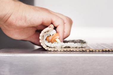 Sushi master turns sushi rolls  clipart