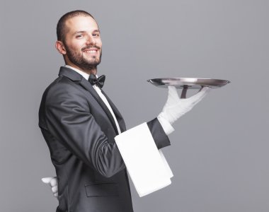 Smiling waiter holding a silver tray clipart