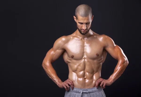 Bodybuilder posiert auf schwarzem Hintergrund — Stockfoto