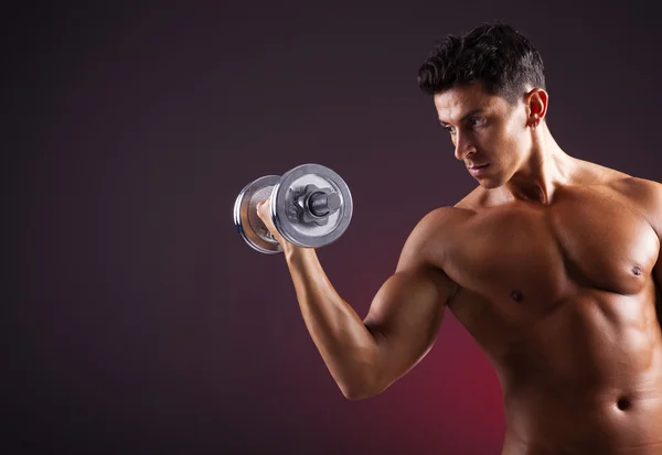 Uomo muscolare sollevamento manubri su sfondo nero — Foto Stock