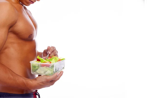 Muskulös man håller en skål med fräsch sallad på vit bakgrund — Stockfoto