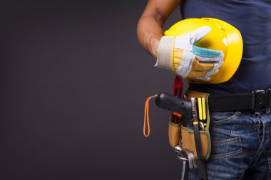 bir işçinin toolbelt ve siyah arka karşı kask ile yakın çekim