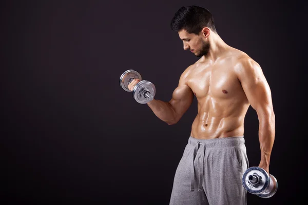 Fitness man lifting dumbbells on black background — Stock Photo, Image