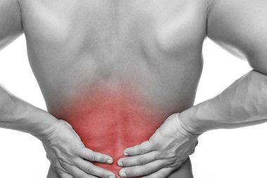 Genç adam acı içinde sırtını tutuyor, beyaz arka planda soyutlanmış.