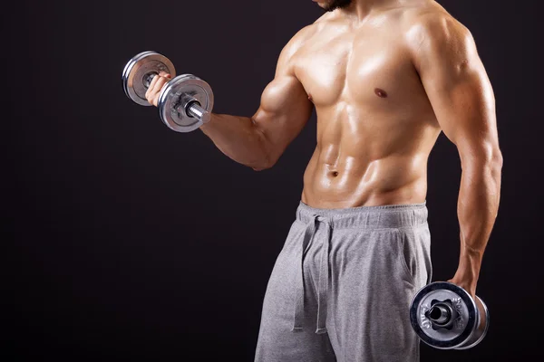 Fitness homem levantando halteres no fundo preto — Fotografia de Stock