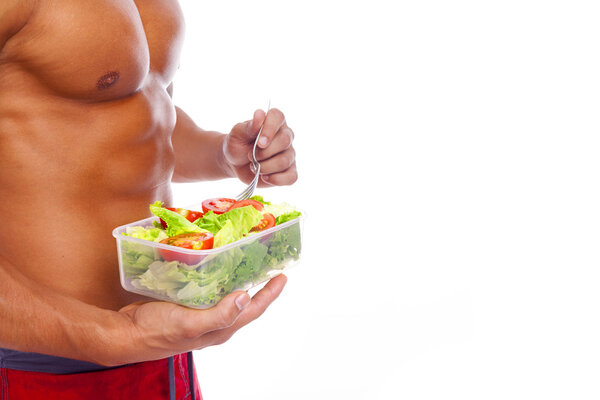 Muscular man holding a bowl of fresh salad