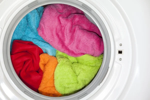 Máquina de lavar roupa com roupas coloridas dentro — Fotografia de Stock