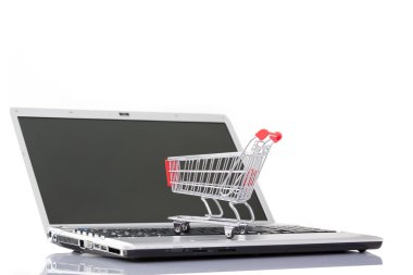 Beyaz backgrou izole bir dizüstü bilgisayar üzerinde alışveriş sepeti