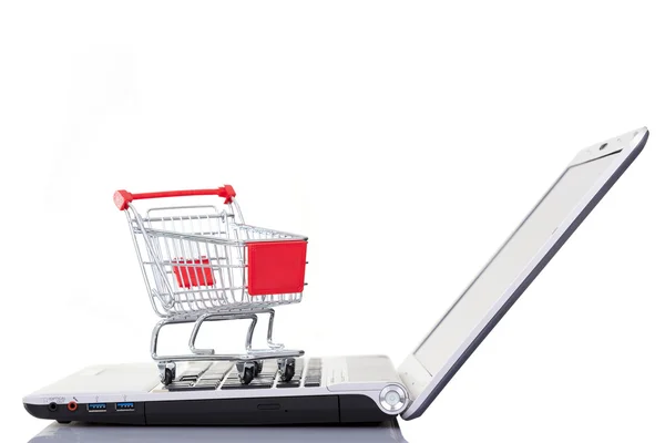 Carro de la compra sobre un ordenador portátil, aislado en backgrou blanco — Foto de Stock