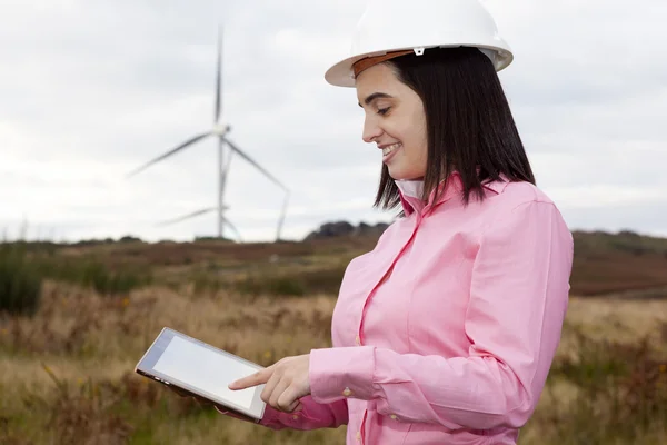 Kvinnliga ingenjör med en tablett vid wind turbine webbplats — Stockfoto