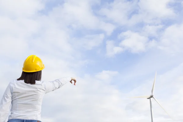 Kvinnliga ingenjör pekar på väderkvarnar — Stockfoto