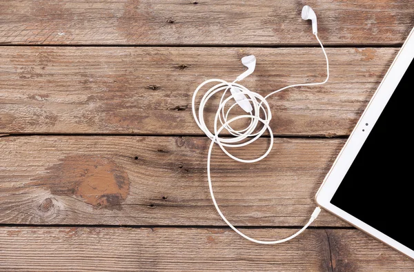 Tablet computer with earphones — Stock Photo, Image