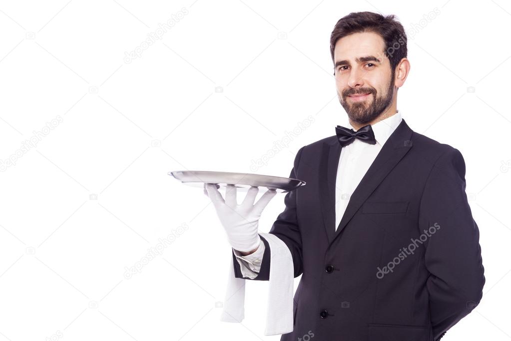 Portrait of handsome waiter holding an empty tray over white bac