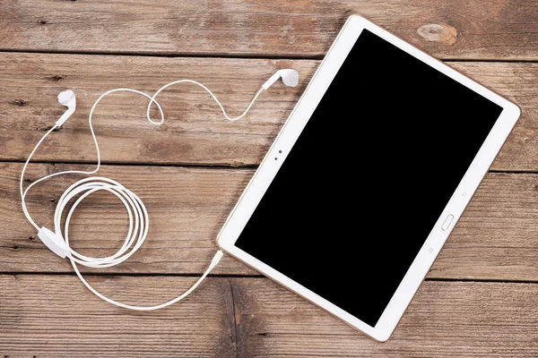 Tableta con auriculares en madera —  Fotos de Stock