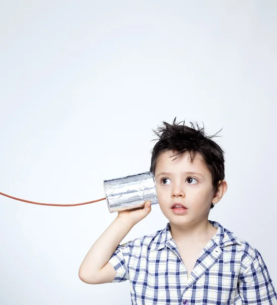 Ребенок с помощью банки в качестве телефона — стоковое фото