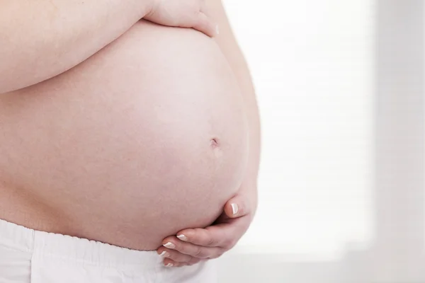 Mulher grávida segurando sua barriga — Fotografia de Stock