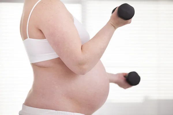 Pregnant woman  with dumbbells — Stock Photo, Image