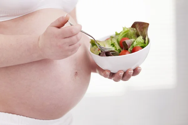 Femme enceinte tenant un bol de salade fraîche — Photo