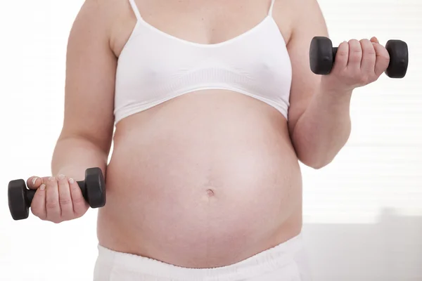 Femme enceinte faisant de l'exercice avec haltères — Photo