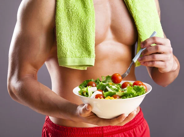Вмістити чоловіка, який тримає тарілку свіжого салату — стокове фото