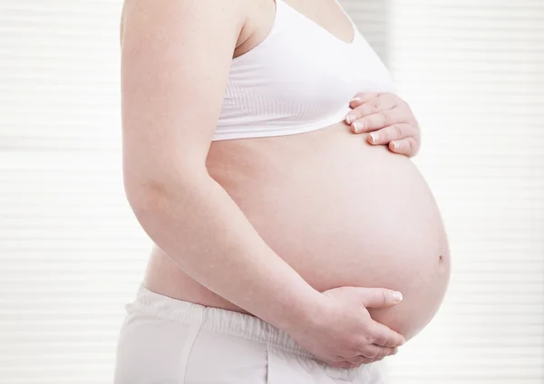 Pregant žena drží jeho břicho — Stock fotografie